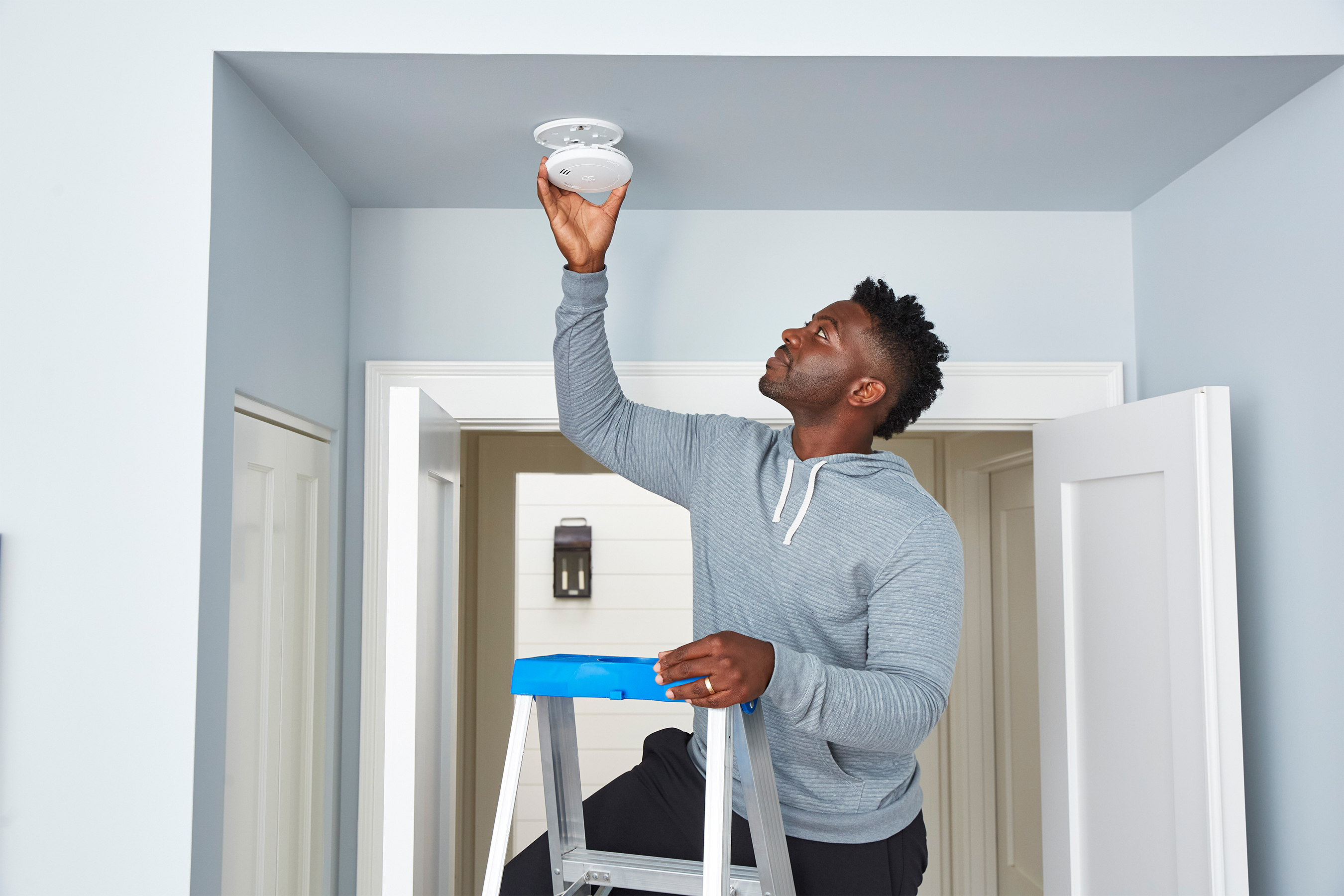 a man installs a smoke detector
